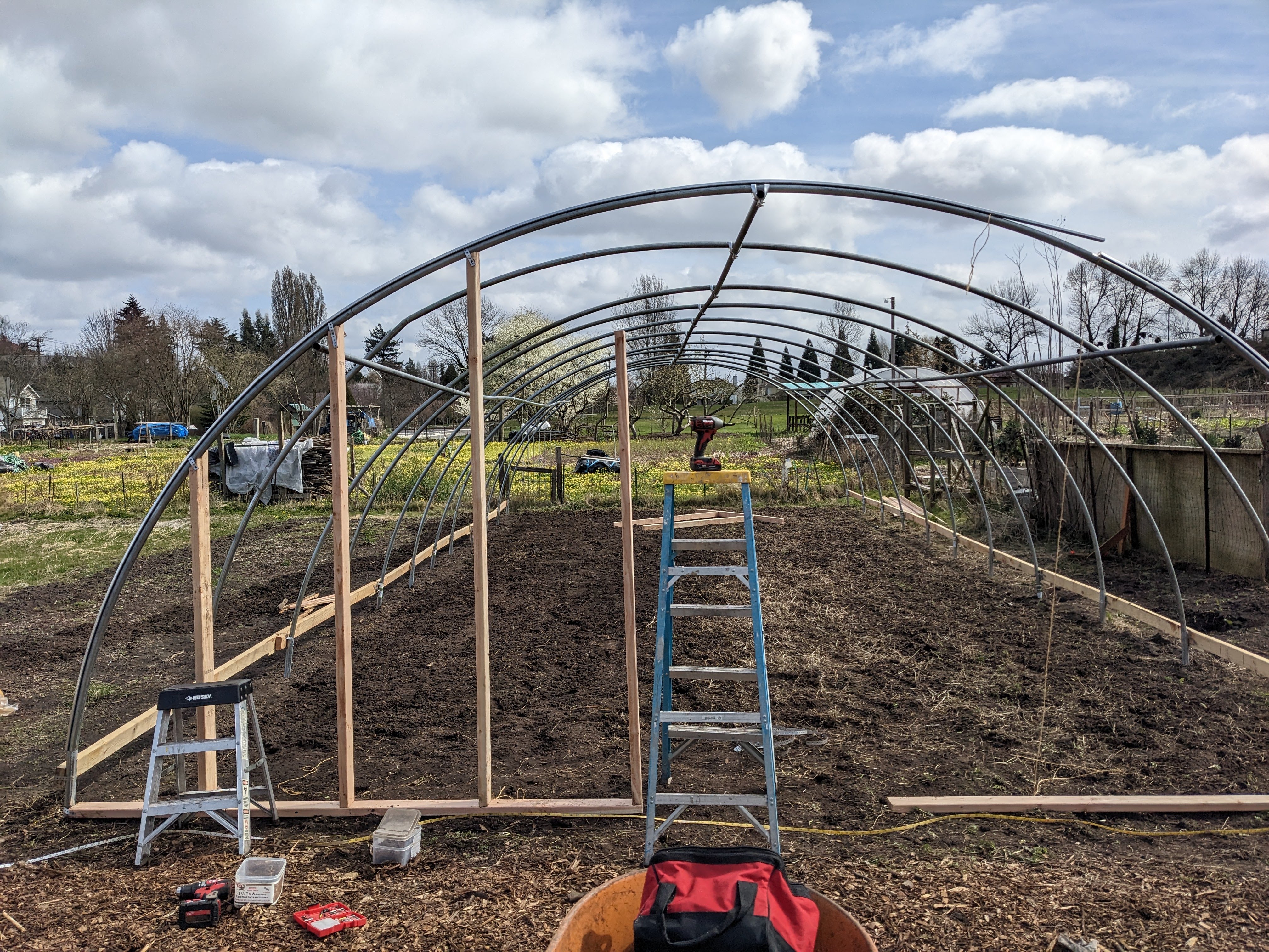 Wood posts are added to the structure of the hoop house.