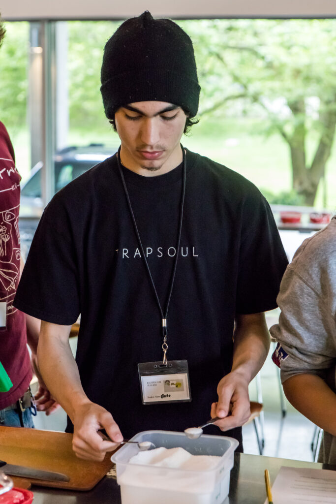 A cooking class student measures ingredients for cookies.