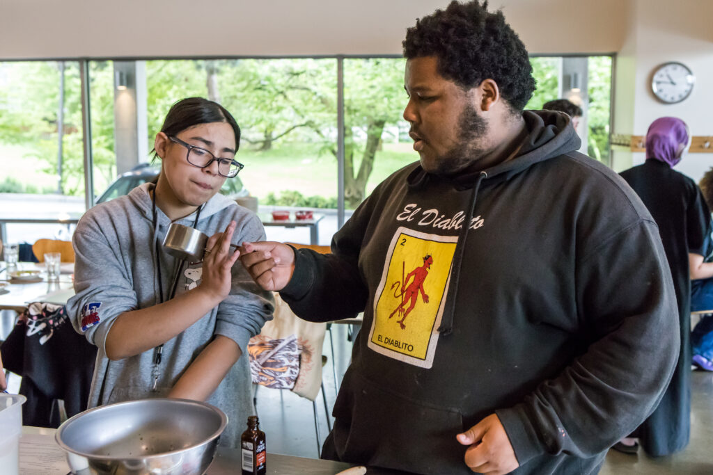 Two cooking class students work on their cookie dough.