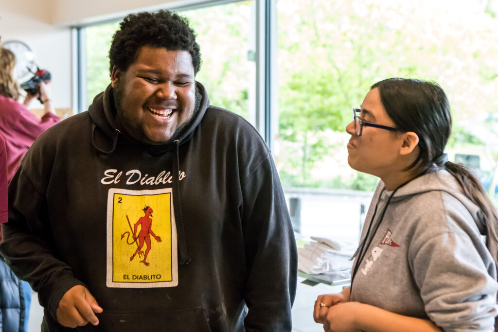 Two cooking class students laugh as they work on their recipe.