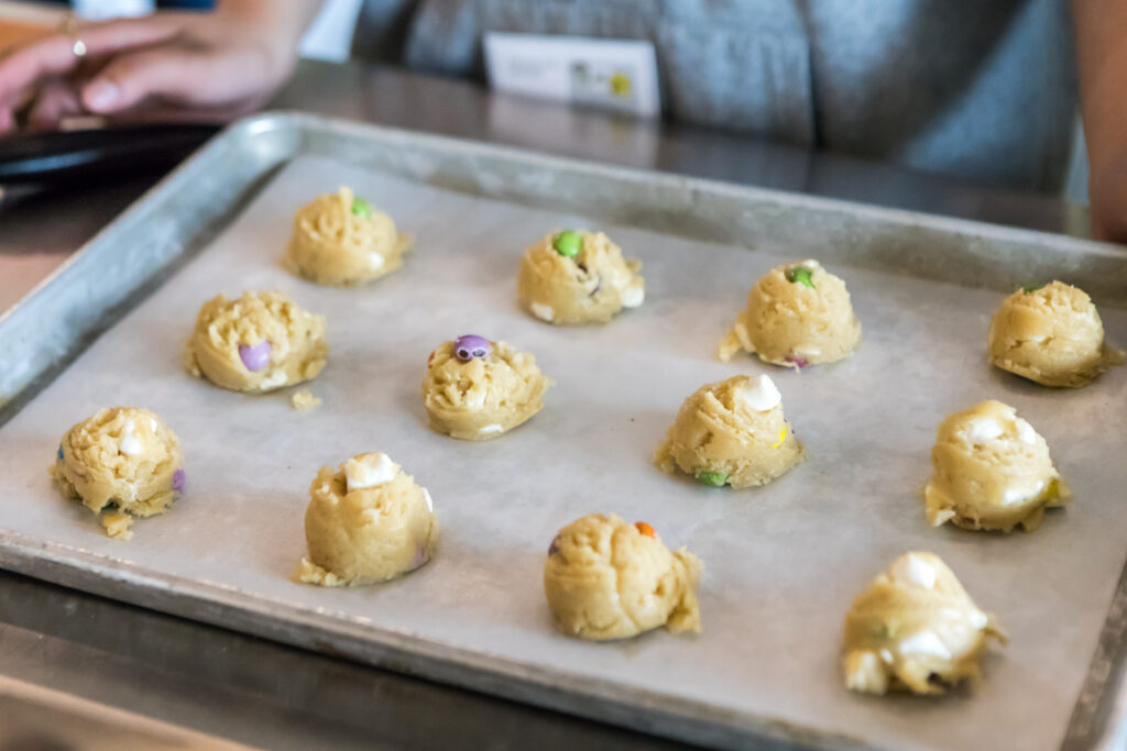 Balls of raw cookie dough on a cookie tray.