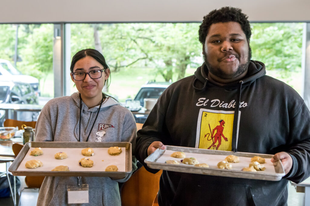 Two cooking class students show off their trays of drop cookies.