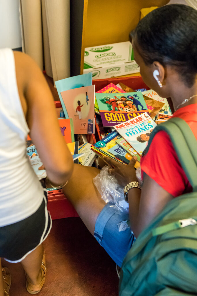 A mother digs through a pile of children's books.