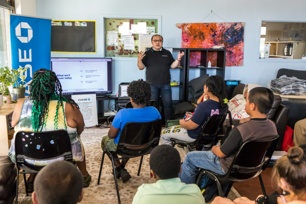 A man gestures while speaking to a crowd.