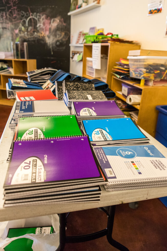 A table stacked high with notebooks.