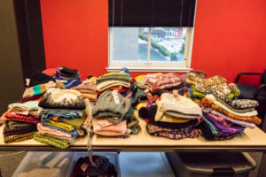 Knitted hats stacked on a table.