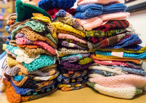 Several stacks of colorful knitted items on a table